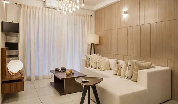 Living room interior with a sofa, coffee table and large windows admitting daylight