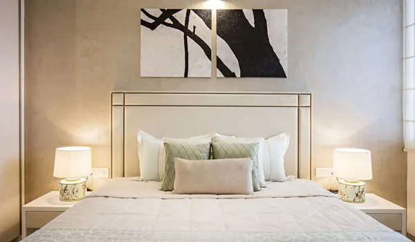 Master bedroom with a large bed, side tables and soft ambient lighting