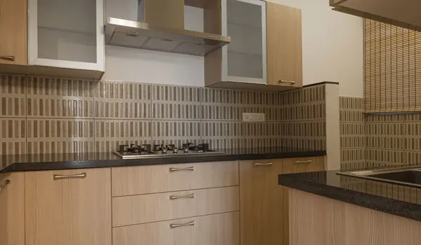 Modular kitchen with overhead cabinets, a countertop hob and integrated appliances