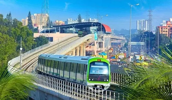 Metro train crossing an elevated viaduct above a city road